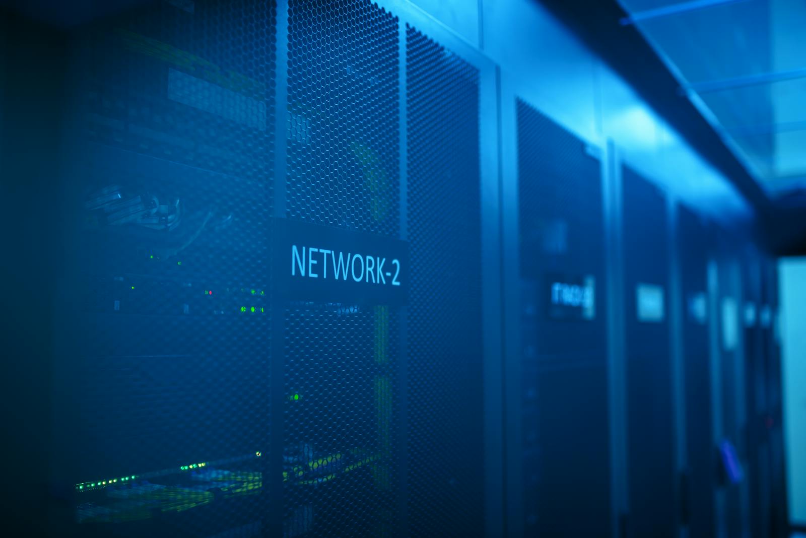 Blue-lit network rack inside a modern server room.